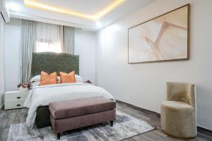 a bedroom with a bed and a chair at Sapphire Heights Apartment Single Rooms in Lagos