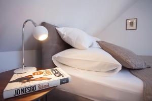 ein Bett mit Kissen und ein Buch auf einem Tisch in der Unterkunft The Square Makarska, LUX app in the heart of the city in Makarska