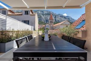 einen Esstisch auf dem Balkon eines Hauses in der Unterkunft The Square Makarska, LUX app in the heart of the city in Makarska