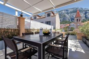 a black table and chairs on a patio with a view at The Square Makarska, LUX app in the heart of the city in Makarska