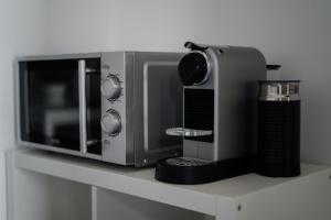 a microwave sitting on a counter next to a cup at DOMUS RESIDENCE - CESARE - in Bari