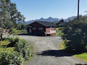 a house with a car parked in front of a driveway at Feriebolig på bygda in Straumsjøen