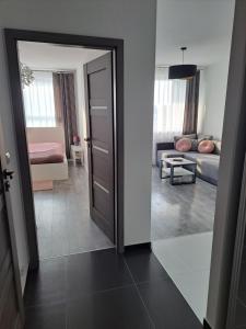 a room with a door leading to a living room at Apartament Pudrowy in Koszalin
