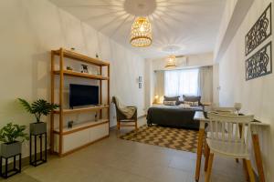 Acevedo 716 - Apart Hotel - New opening في بوينس آيرس: غرفة نوم مع سرير وغرفة معيشة مع تلفزيون