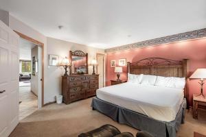 a bedroom with a large white bed and a mirror at Copper Junction 305 in Frisco