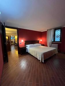 ein Schlafzimmer mit einem Bett und einer roten Wand in der Unterkunft Petite Home in Roccaraso