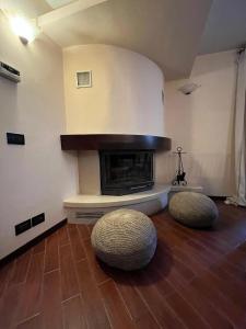 ein Wohnzimmer mit einem Kamin und 2 Hockern in der Unterkunft Petite Home in Roccaraso