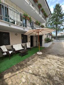 a patio with an umbrella in front of a building at Petite Home in Roccaraso