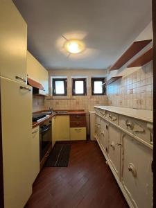 eine große Küche mit weißen Geräten und Holzböden in der Unterkunft Petite Home in Roccaraso