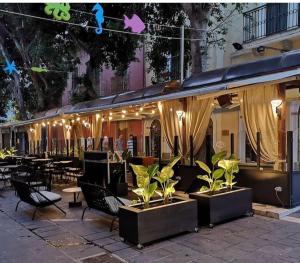 un restaurante con sillas, mesas y luces en Hotel Del Corso, en SantʼAntìoco