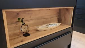 a wooden shelf with a bowl and a plant on it at Modern Loft near City I free Parking I WiFi in Bochum +54 photos