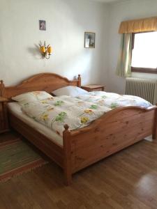 a bed in a bedroom with a wooden bed frame at Pension Brixen im Thale in Brixen im Thale +18 photos