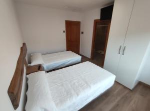 Habitación pequeña con 2 camas y armario en Hostal San Juan, en Sahagún