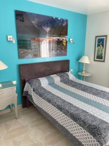Schlafzimmer mit einem Bett mit blauer Wand in der Unterkunft L'Abribis in Firminy