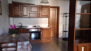 a kitchen with wooden cabinets and a stove top oven at Residence Domus in Pisa