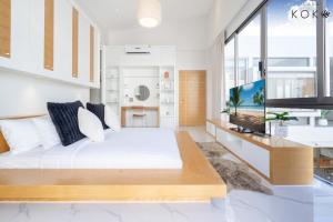 Villa Casa Koko Phuket - Stay in Style في تالانغ: غرفة نوم بسرير ابيض كبير وتلفزيون