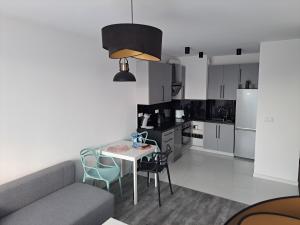 a kitchen and living room with a table and chairs at Apartament Pudrowy in Koszalin