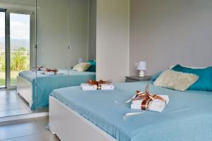 2 letti in una camera con blu e bianco di Hyele Accommodation Experience a Casal Velino