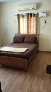 ein Bett in einem Schlafzimmer mit Holzboden in der Unterkunft SRI SANKARA VILLAS -- Aditya Heritage in Kumbakonam + 21 Fotos