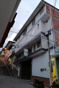 a white building with a balcony on a street at Aparta-Hotel El Dorado in Aguadas