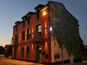 a red brick building with a balcony on a street at Ogrodowa Premium in Gorlice