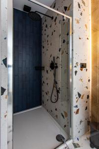 a bathroom with a glass shower with a rock wall at Ogrodowa Premium in Gorlice