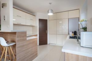 a kitchen with white cabinets and a white counter top at Rekreačný domček Flower Garden - Self Check In in Dolný Kubín