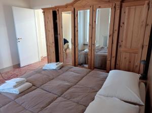 1 dormitorio con 1 cama grande y toallas. en Rifugio escursionistico ex-scuola Grassi, Bubbio en Bubbio