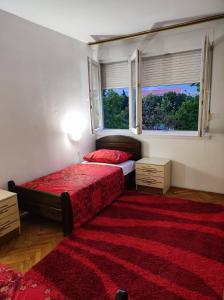 a bedroom with two beds and a red rug at Luka in Split