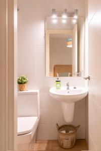 bagno con lavandino, servizi igienici e specchio di LUCIA DE TRIANA a Siviglia
