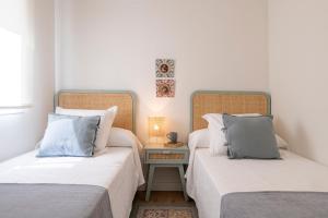 two beds sitting next to each other in a room at LUCIA DE TRIANA in Seville