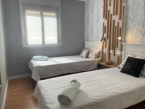 1 dormitorio con 2 camas y ventana en Precioso apartamento muy cerca de Méndez Alvaro, en Madrid