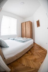 a bedroom with a bed with a wooden headboard at APARTMAN TEA 3 in Čukarica