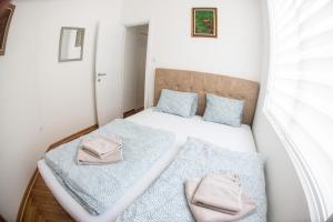 a small bedroom with two beds with blue pillows at APARTMAN TEA 3 in Čukarica