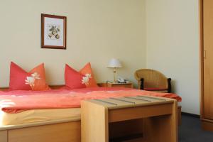 ein Schlafzimmer mit einem großen Bett mit roten Kissen in der Unterkunft pension Helga in Bad Dürkheim