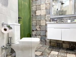 y baño con aseo blanco y lavamanos. en 6 Unique Apartments, en Tiflis