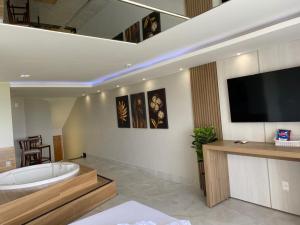 a bathroom with a tub and a tv on the wall at Motel Colorado (Adult Only) in Brasilia