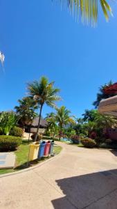 a street with palm trees and trash cans on a sidewalk at Condomínio HotSprings Hotel - Apartamento 1003 in Caldas Novas