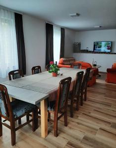 uma sala de jantar com uma mesa e cadeiras e um sofá em Jaćimov Konak em Pirot