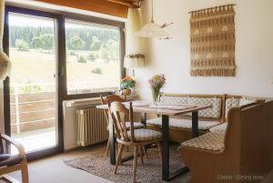 uma sala de jantar com uma mesa e cadeiras e uma janela em 71 square meters Condo in Schwarzwald with beautiful mountain view, free wifi em Schönwald