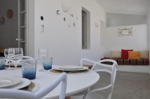 una sala da pranzo bianca con tavolo e sedie bianchi di Casa do Mercado ad Alcácer do Sal