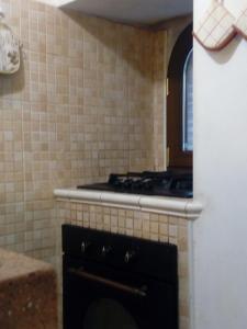 a kitchen with a stove and a tile wall at Dimora Volturno in Vasto