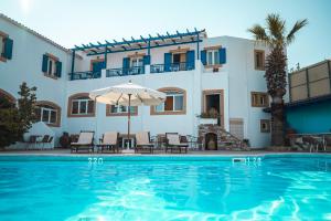 a villa with a swimming pool in front of a building at Venardos Hotel in Agia Pelagia Kythira
