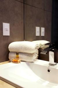baño con lavabo blanco y toalla en Hotel Buen Valle en Torreón