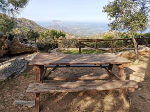 una mesa de picnic de madera en la cima de una colina en Wonderland en San Teodoro