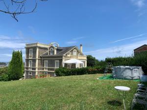 a large house on a grassy yard with a playground at Villa Auristela in Navia