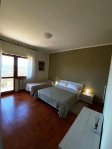 1 dormitorio con 2 camas y ventana grande en Il Panorama di Trevi, en Trevi