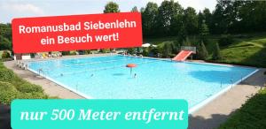 a large swimming pool with a sign in front of it at Monteurzimmer Siebenlehn in Siebenlehn
