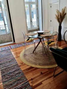 a dining room with a table and chairs on a wooden floor at Appartement Pont Luiz in Porto