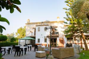 a patio with tables and chairs in front of a building at Il Casale Le Tre Volte in Solfara Mare
